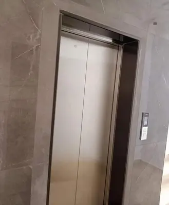 a shower stall in a bathroom with a metal door at Alshakreen suites in Amman