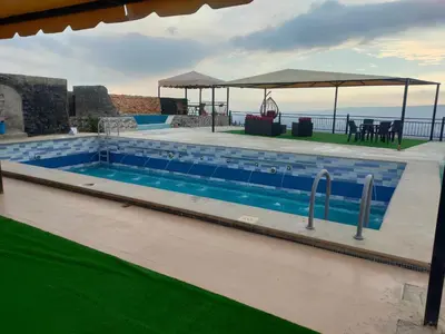 a swimming pool with a view of the ocean at Magical Rosemary Chalet in Al Mashāriqah