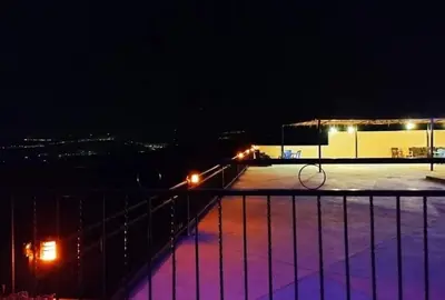 a tennis court at night with a racket at Magical Rosemary Chalet in Al Mashāriqah