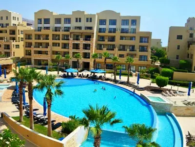 a large swimming pool with palm trees and buildings at EP2 Samarah Resort in Sowayma