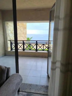 a room with a balcony with a view of the ocean at EP2 Samarah Resort in Sowayma