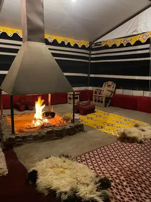 a living room with a fireplace and a couch at nature camp in Wadi Rum