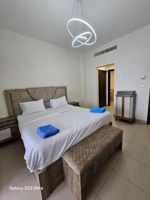 a bedroom with a large bed with blue towels on it at E13 Samarah Resort Apartment in Sowayma