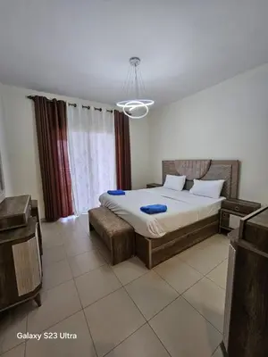 a bedroom with a bed and a chandelier at E13 Samarah Resort Apartment in Sowayma