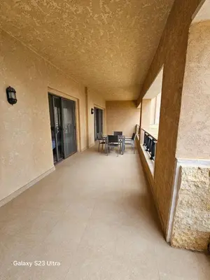 an empty hallway with tables and chairs in a building at E13 Samarah Resort Apartment in Sowayma