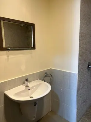 a bathroom with a white sink and a mirror at E03 Samarah Resort Apartments in Sowayma