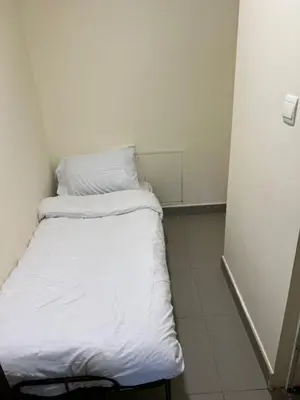 a small bed with white sheets in a room at E03 Samarah Resort Apartments in Sowayma
