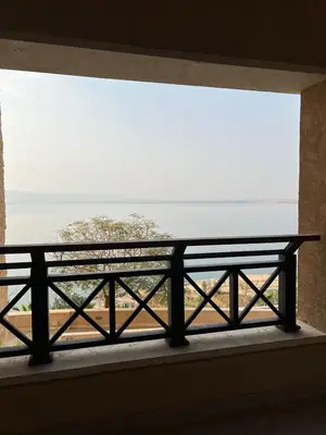 a view of the ocean from a window with a bench at E03 Samarah Resort Apartments in Sowayma