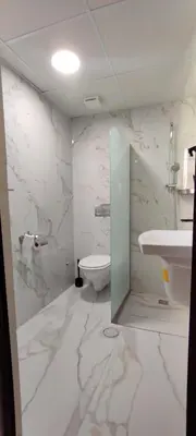 a white bathroom with a toilet and a sink at Moab Land Hotel in Madaba