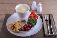 a plate of fruit and vegetables and a cup of coffee at Prime Hotel in Amman