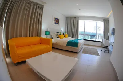 a bedroom with a bed and a chair and a window at Prime Hotel in Amman