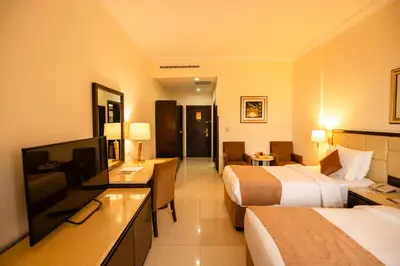 a hotel room with two beds and a flat screen tv at East hotel in Sowayma