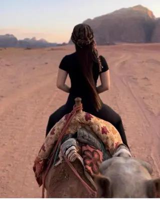a woman riding on the back of an elephant in the desert at Rum Gonesh Luxury Camp in Wadi Rum