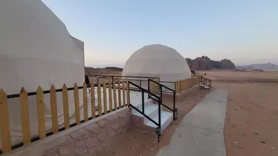 a building in the middle of the desert with a fence at Rum Gonesh Luxury Camp in Wadi Rum