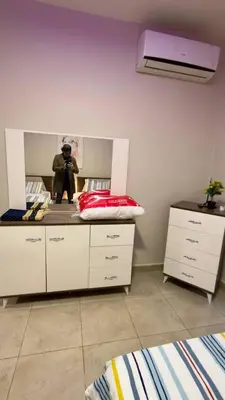 a bedroom with a bed and a mirror with a man standing in the mirror at 2 bedrooms apartment no 18 in Amman