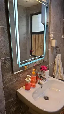 a bathroom sink with a large mirror above it at 2 bedrooms apartment no 18 in Amman