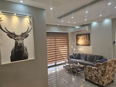 a living room with a painting of a deer on the wall at 2 bedrooms apartment no 18 in Amman
