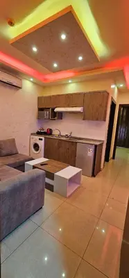 a living room with a couch and a kitchen at MOTAMEZ APARTMENTS in Amman