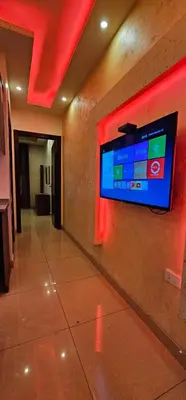 a flat screen tv on a wall in a building at MOTAMEZ APARTMENTS in Amman