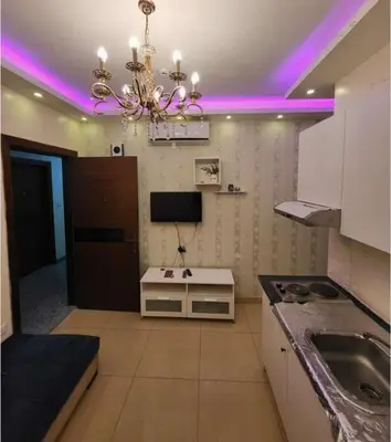a kitchen with a chandelier with purple lights on it at MOTAMEZ APARTMENTS in Amman
