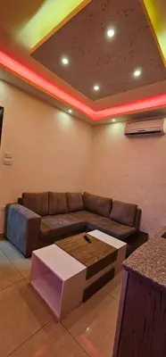 a living room with a couch and a table at MOTAMEZ APARTMENTS in Amman