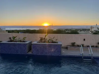 a swimming pool with a sunset in the background at Deadsea Elite First floor shared swimming pool in Sowayma