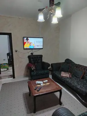 a living room with a couch and two chairs and a table at الشقة العائلية الحديثة familial new flat in Amman