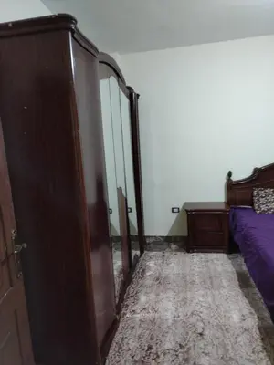 a bedroom with a bed and a dresser and a door at الشقة العائلية الحديثة familial new flat in Amman