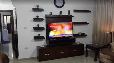 a living room with a flat screen tv on a entertainment center at Shahed Apartment in Amman