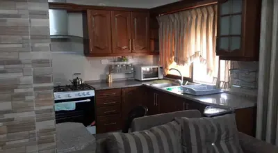 a kitchen with wooden cabinets and a stove top oven at Shahed Apartment in Amman