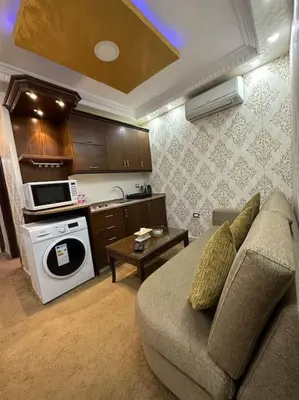 a living room with a couch and a kitchen at al-burj apart at 7th circle in Amman