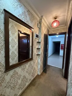 a hallway with a mirror on the wall and a hallway with a door at al-burj apart at 7th circle in Amman