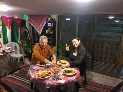 a man and a woman sitting at a table with food at The guset house in Kerak