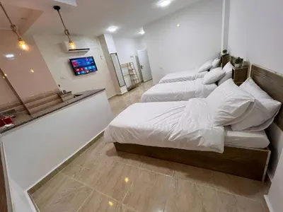 a bedroom with two beds with white sheets at The guset house in Kerak