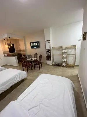 a room with two beds and a table and chairs at The guset house in Kerak