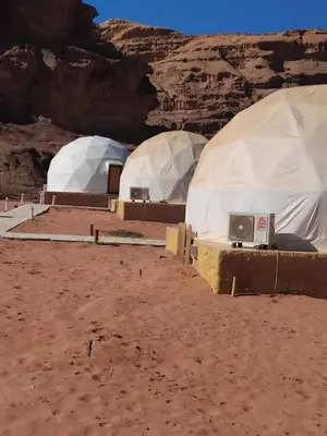 a row of domes in the desert with a tv at Quite bubble tent in Wadi Rum