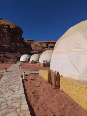 a group of domes in a desert with a mountain at Quite bubble tent in Wadi Rum