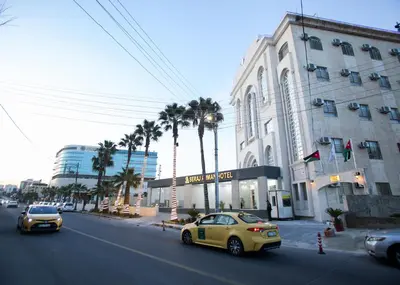 a yellow car driving down a street next to a building at Seraj Amman Hotel in Amman