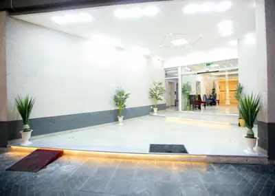 an empty lobby with potted plants in a building at Seraj Amman Hotel in Amman