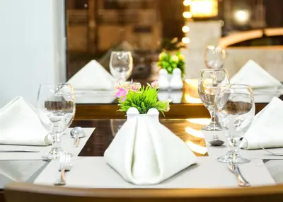 a table with wine glasses and a vase with flowers at Seraj Amman Hotel in Amman