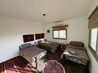 a room with two beds and a couch in it at Eman house in Wadi Musa