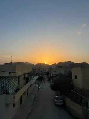 a sunset over a city with a street and buildings at Eman house in Wadi Musa