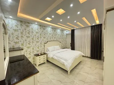 a bedroom with a bed and floral wallpaper at شقق فندقية فاخرة in Amman