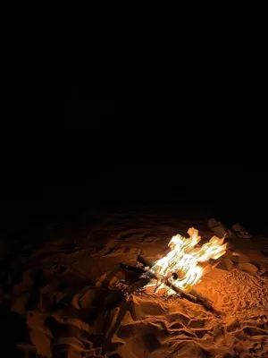 a fire in the sand in the dark at Abdul Rahman Wadi Rum in Wadi Rum