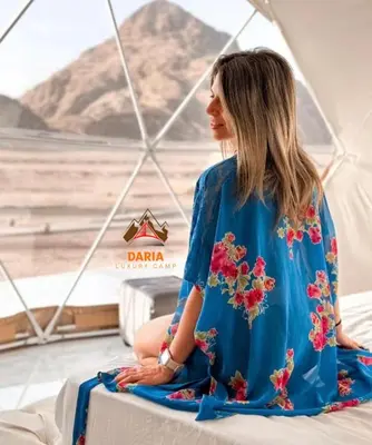 a woman sitting in a tent looking out at the desert at Abdul Rahman Wadi Rum in Wadi Rum