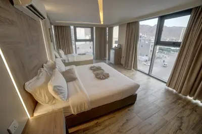 a bedroom with a large bed with a large window at Alena Boutique Hotel in Aqaba