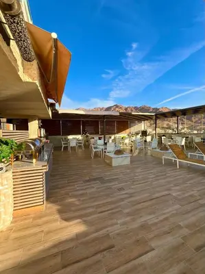 a patio with white chairs and tables on a building at Alena Boutique Hotel in Aqaba