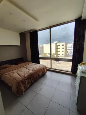 a bedroom with a bed and a large window at Gentle Breeze Studio 3 in Amman