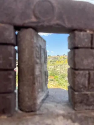 a window in a brick wall with a view at Al-Bustan House& Umm Qais in Um Qeis