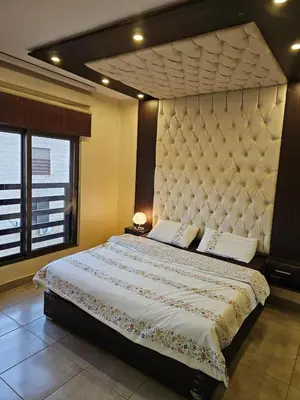 a bedroom with a large bed with a large headboard at Apartment no 30 in Amman